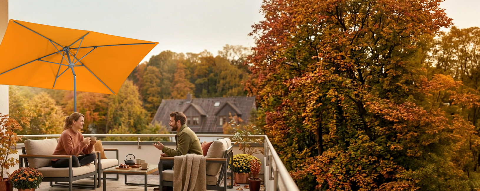 Schneider Schirme Tunis 270 x 150 cm in mandarin in use. (AI-generated image) Two people are seated on a lounge on a balcony beneath the Schneider Tunis parasol (270 × 150 cm). In the background, a house is surrounded by trees in their autumn colors. AI-generated image.